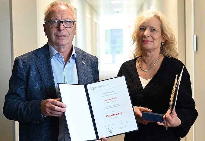 Dr. med. Edgar Pinkowski, Präsident der Landesärztekammer Hessen, überreicht die Ehrenplakette an Katja Möhrle. 2025_10_16_Ehrenplakette_Katja_Moehrle.JPG